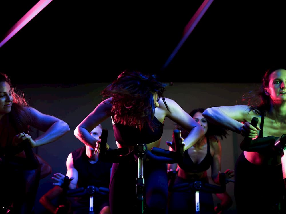 People spinning in a dark room