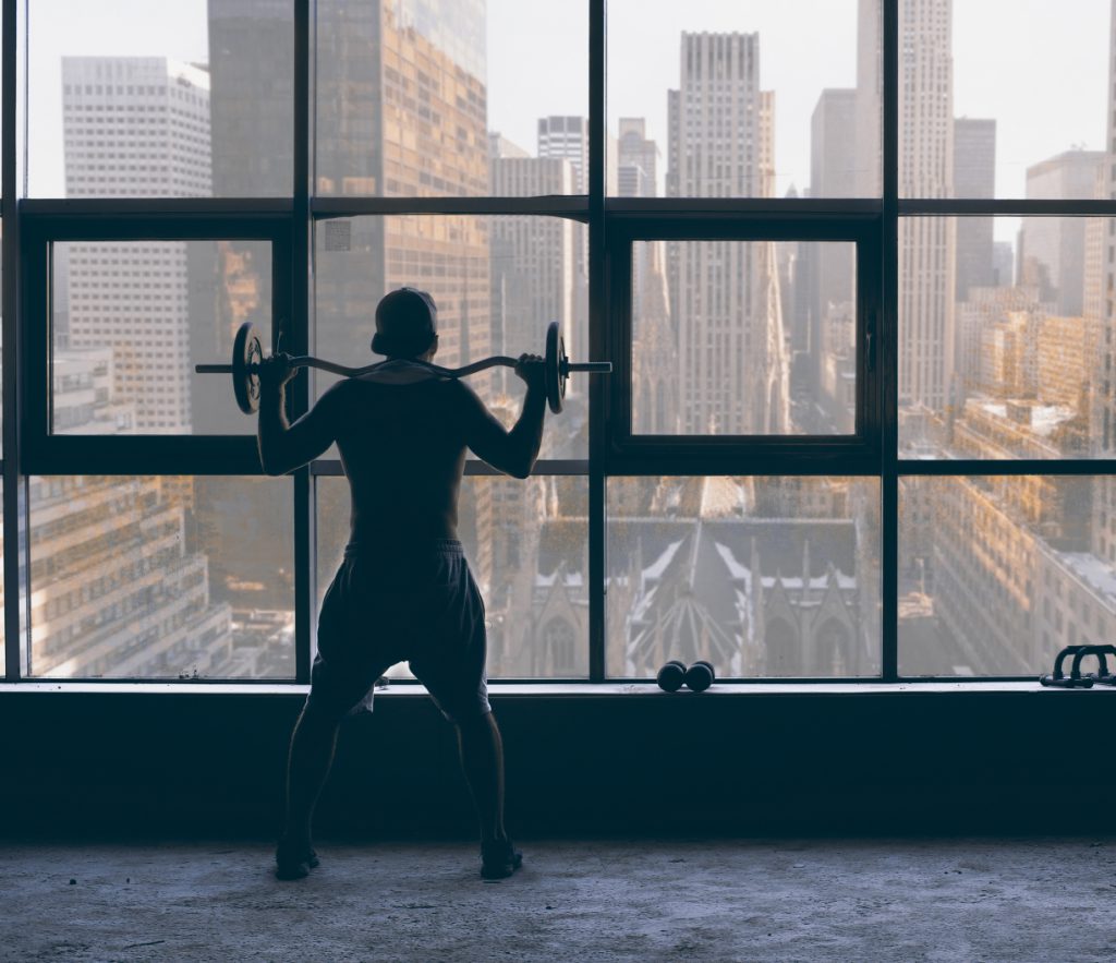 Guy with weights looking outside on New York